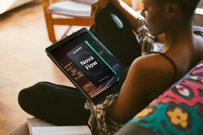 Person holding a tablet with a HYML/CSS/JS course on it, sitting on a couch.