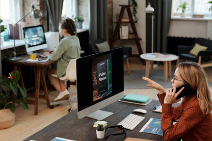 Woman on phone at a desk with computer and office setup